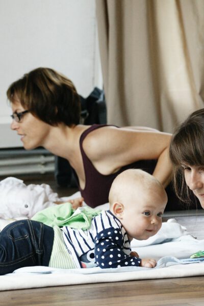 Frauen machen Postnatal Yoga mit ihren Babys.