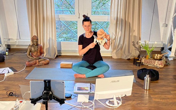 Eine Yoga Lehrerin erkärt im Yoga Workshop im Yogaraum Ravensburg den Körperbau einer Hüfte an einem Modell.